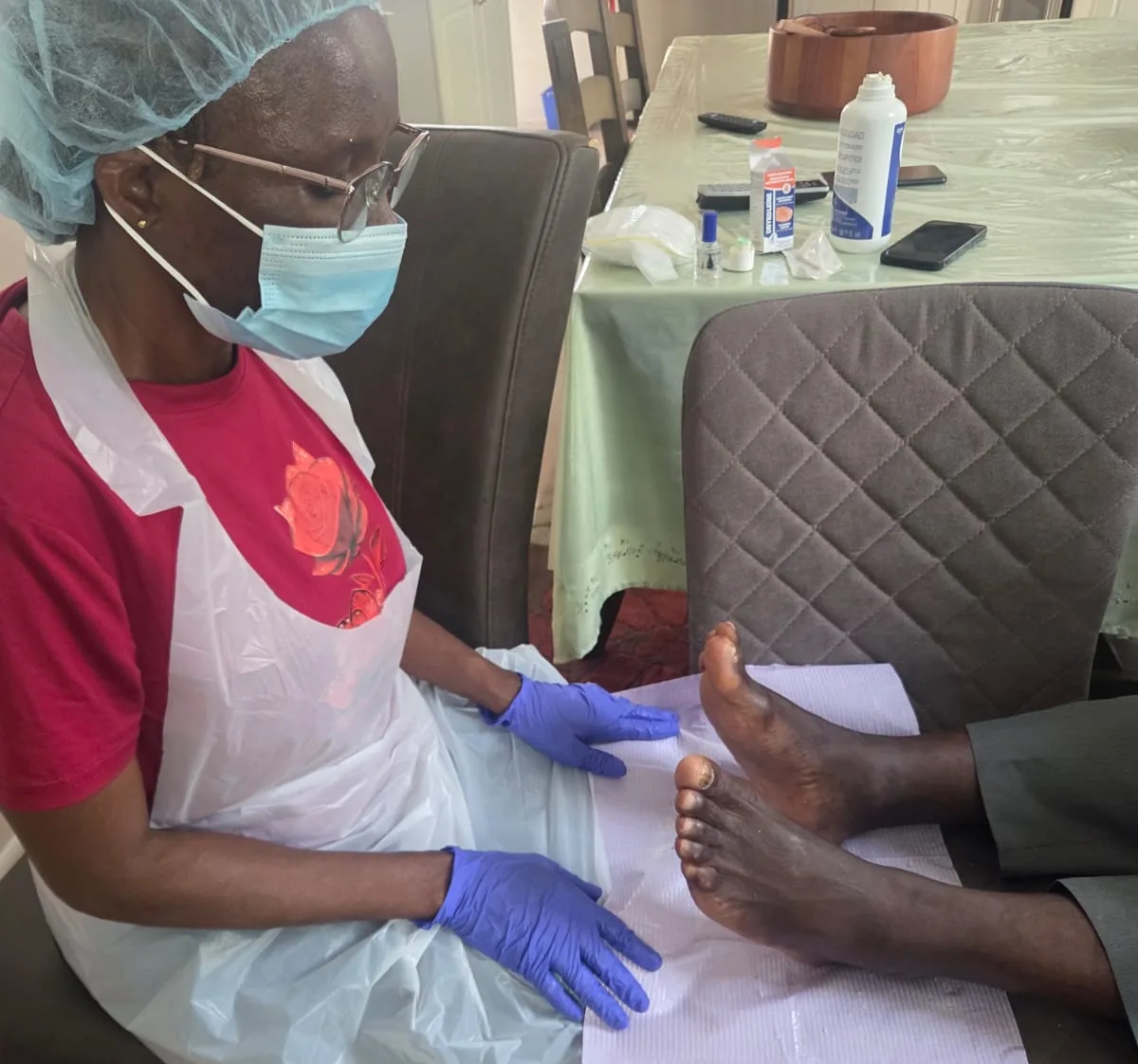 Viviane Peguy Kouassi soigne un pied au domicile d'un patient